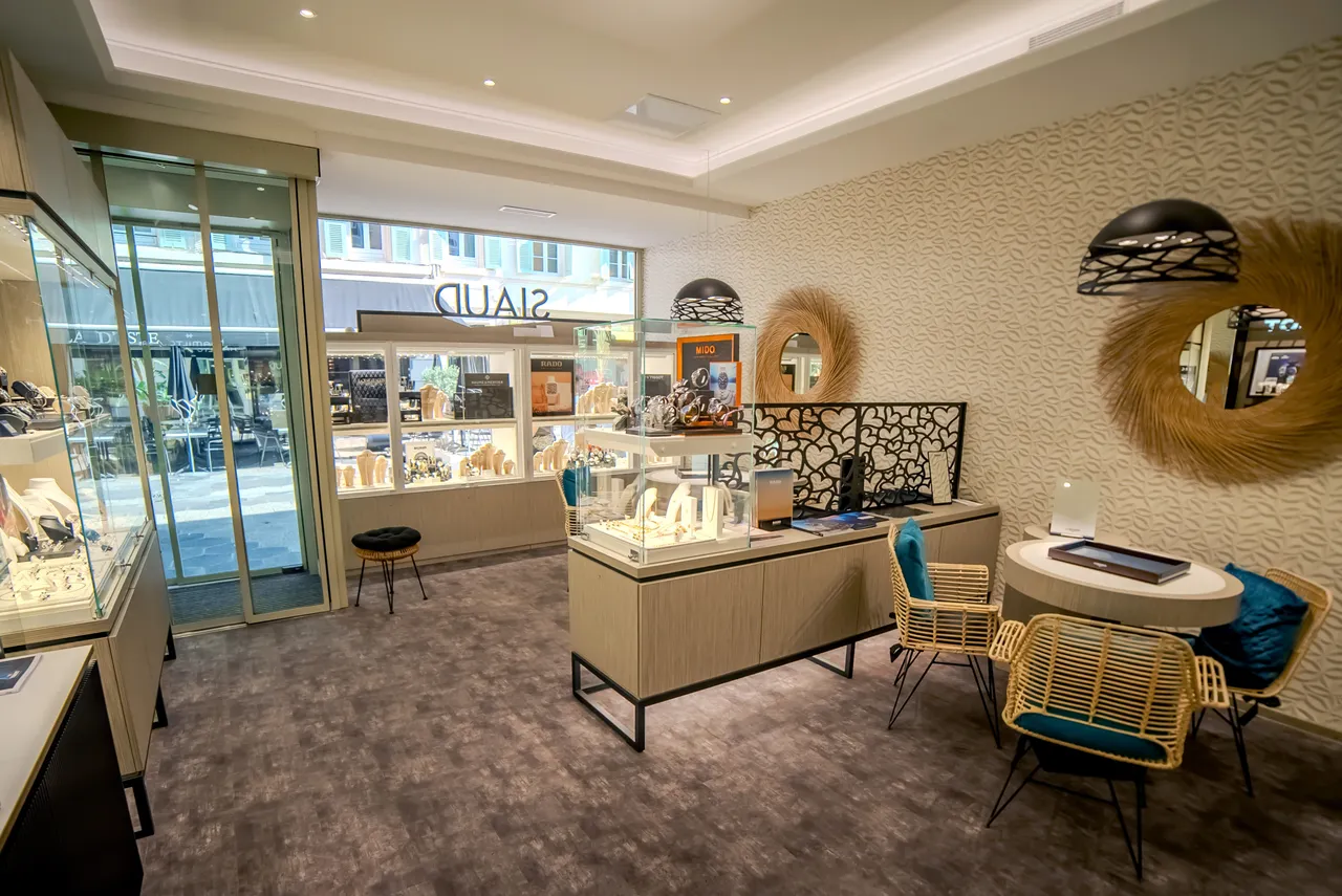 Intérieur de la boutique SIAUD rue Masséna à Nice, vitrines de montres et vue sur la vitrine côté rue