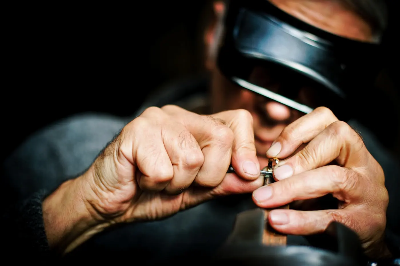 Joaillier sertissant une bague en or à la loupe — création sur mesure, atelier SIAUD à Nice